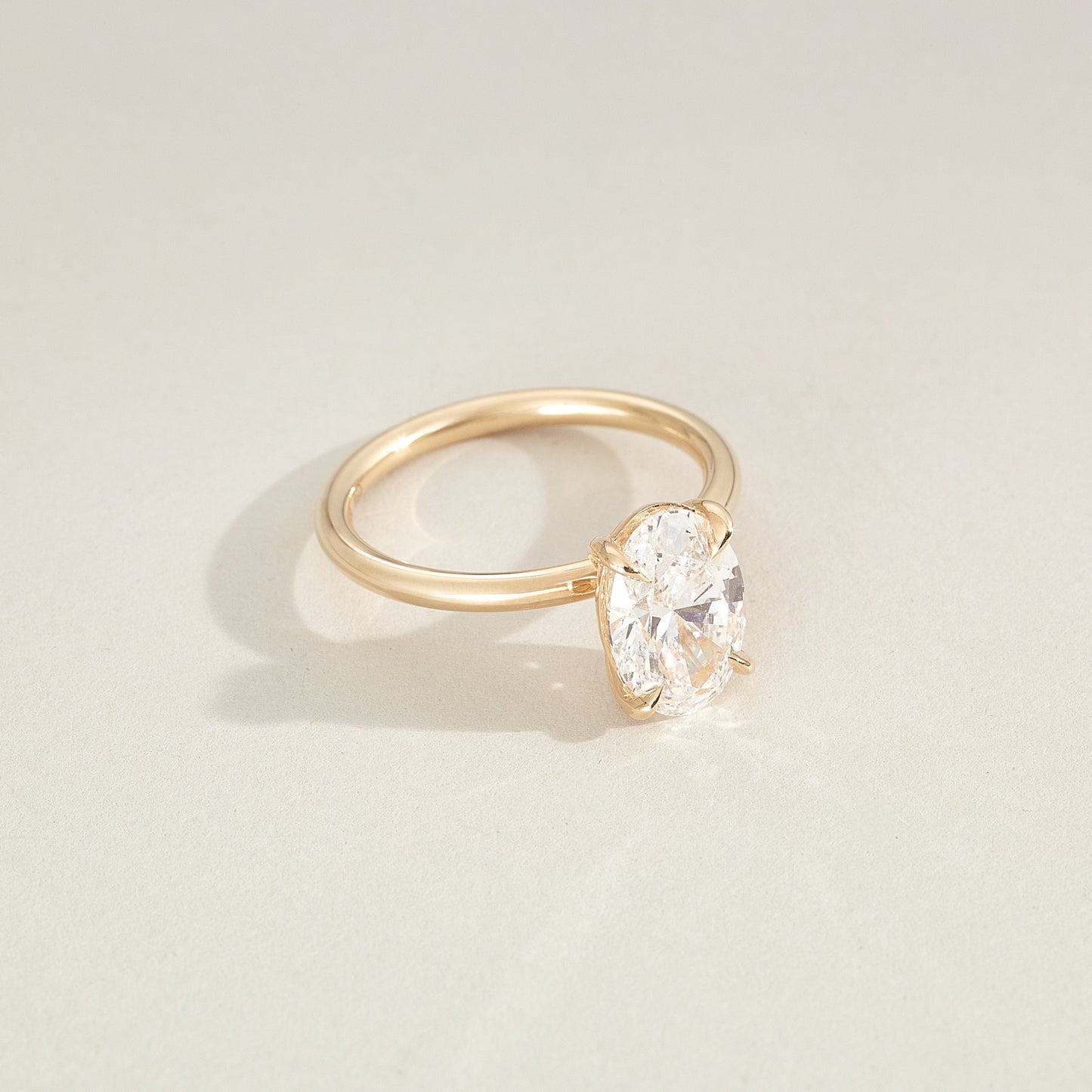 Gold ring with a diamond on a light beige background