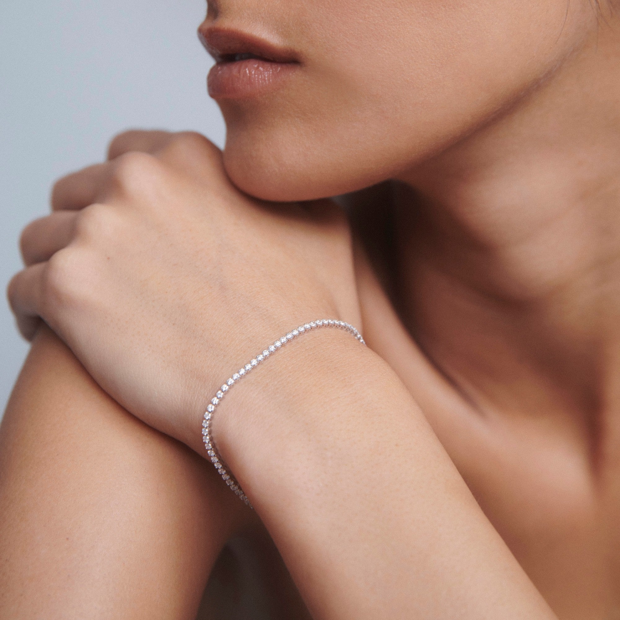 Woman wearing elegant diamond bracelet on wrist, close-up. Luxurious jewellery, minimalistic elegance.
