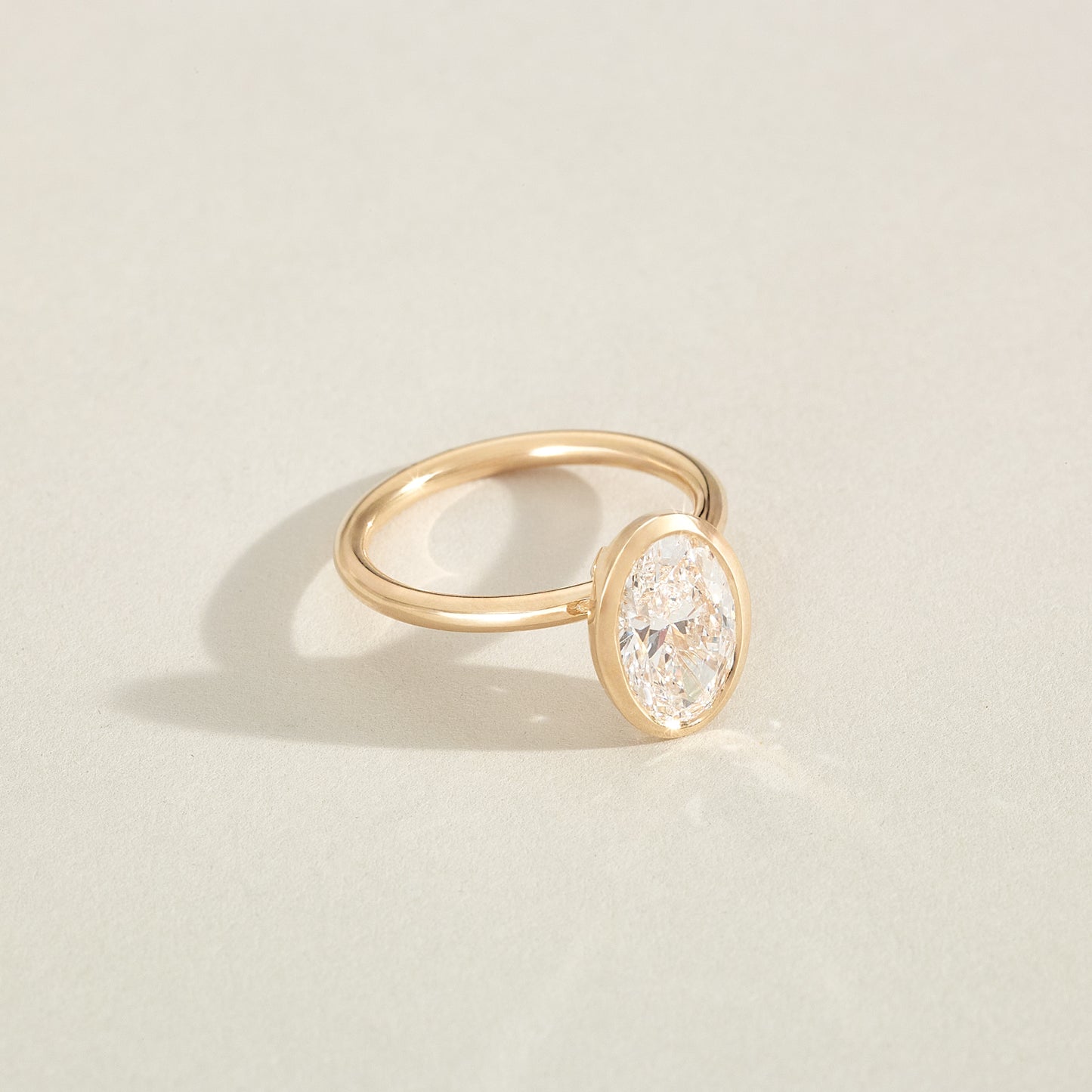 Gold ring with a diamond on a light beige background