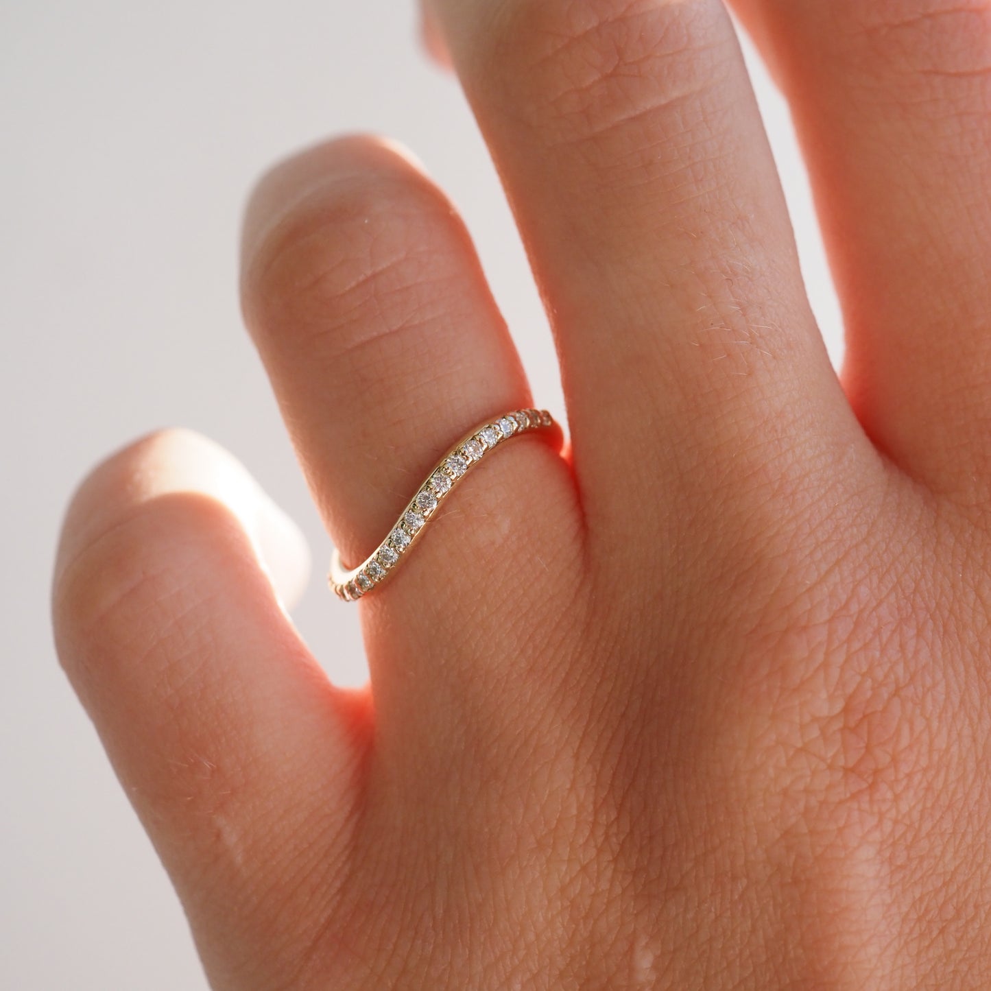 Elegant gold ring with diamonds on hand, showcasing luxury jewellery. Perfect for use in high-end fashion and wedding accessories. [text overlay: Fine] [text colour: #000000]

