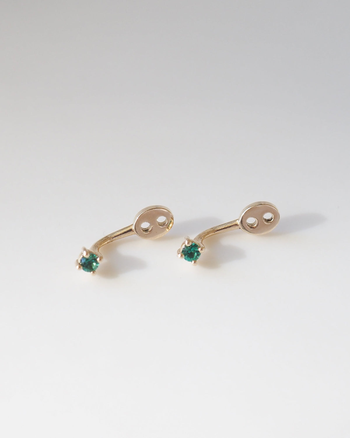 9ct gold earring jackets with alexandrite gemstones on a light background