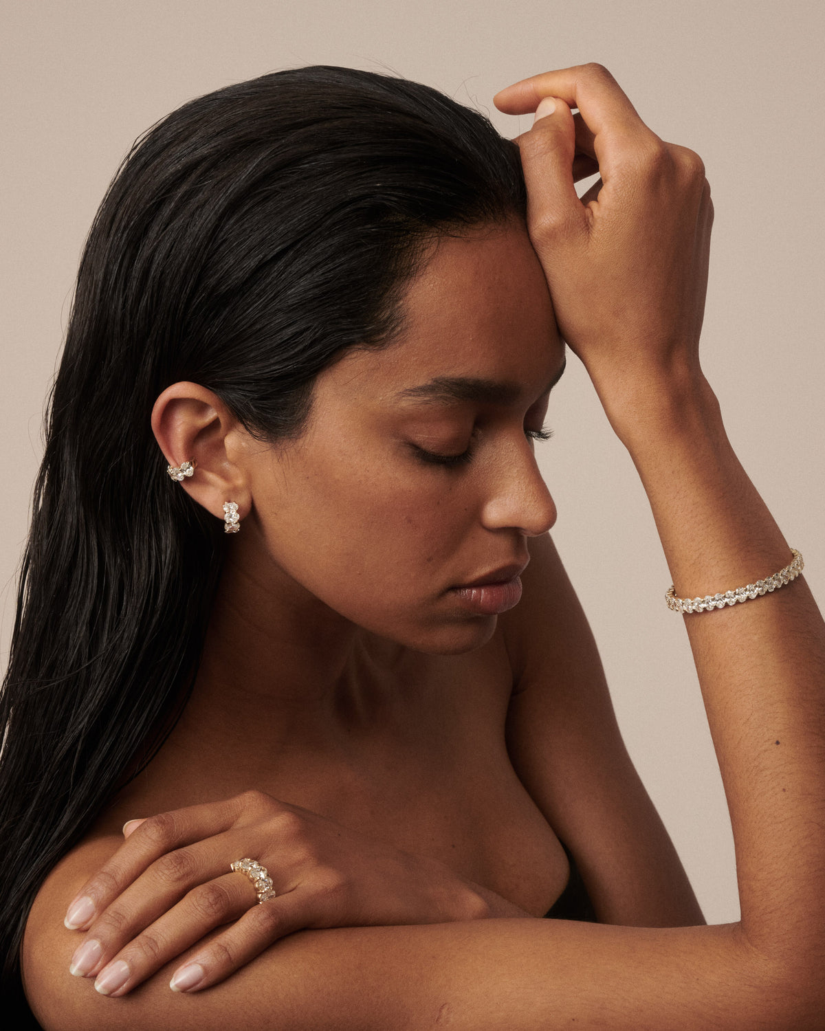 Gold oval lab-grown diamond cuff and stud earrings, side view with hand visible