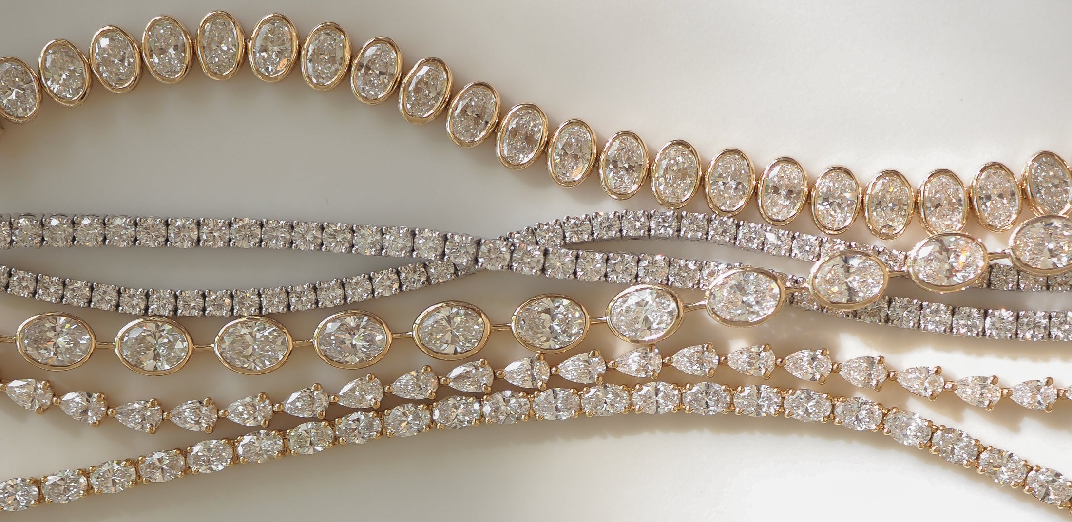 Elegant diamond necklaces with oval and round stones set in gold and silver, showcasing luxury jewellery craftsmanship.