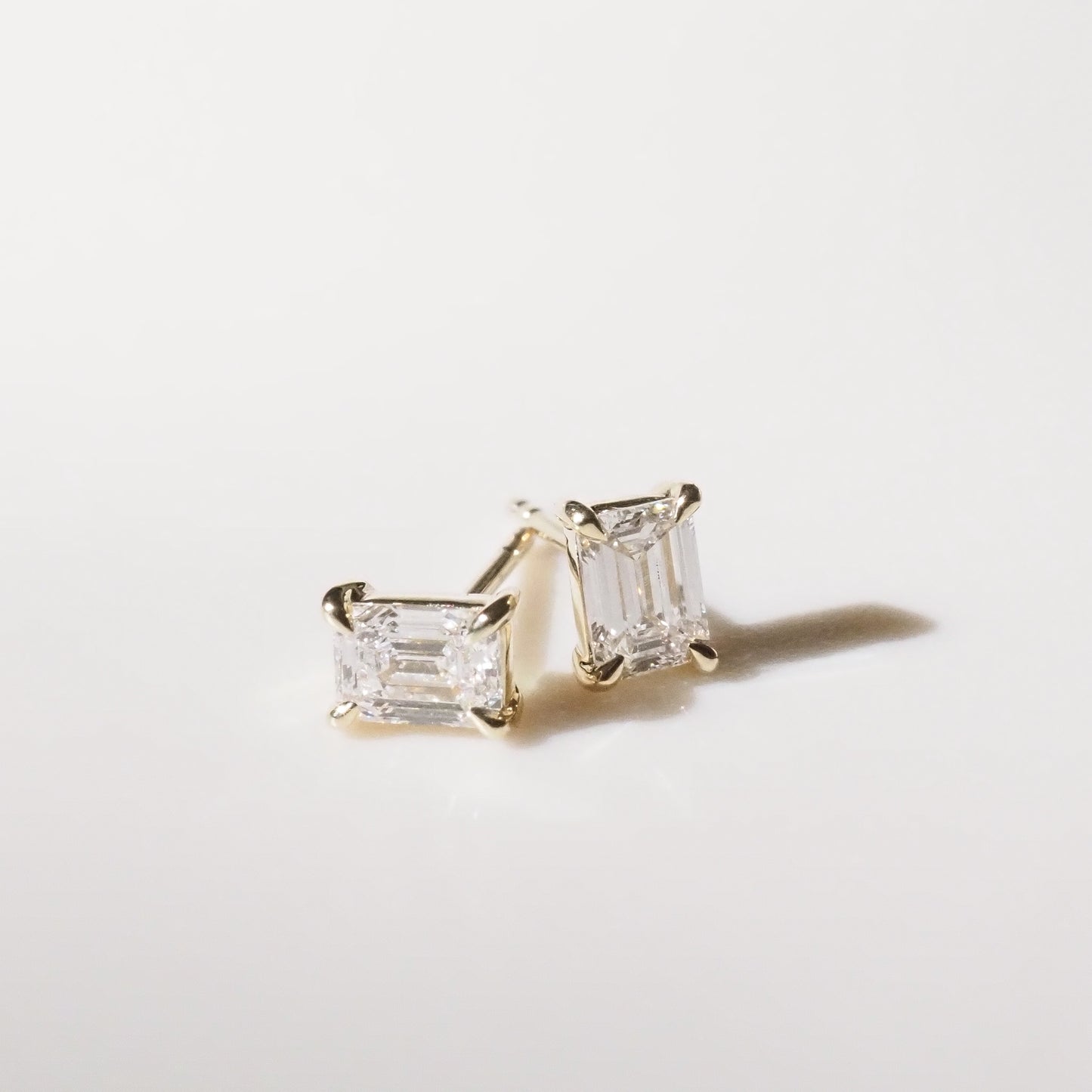Pair of diamond stud earrings on a light gray background