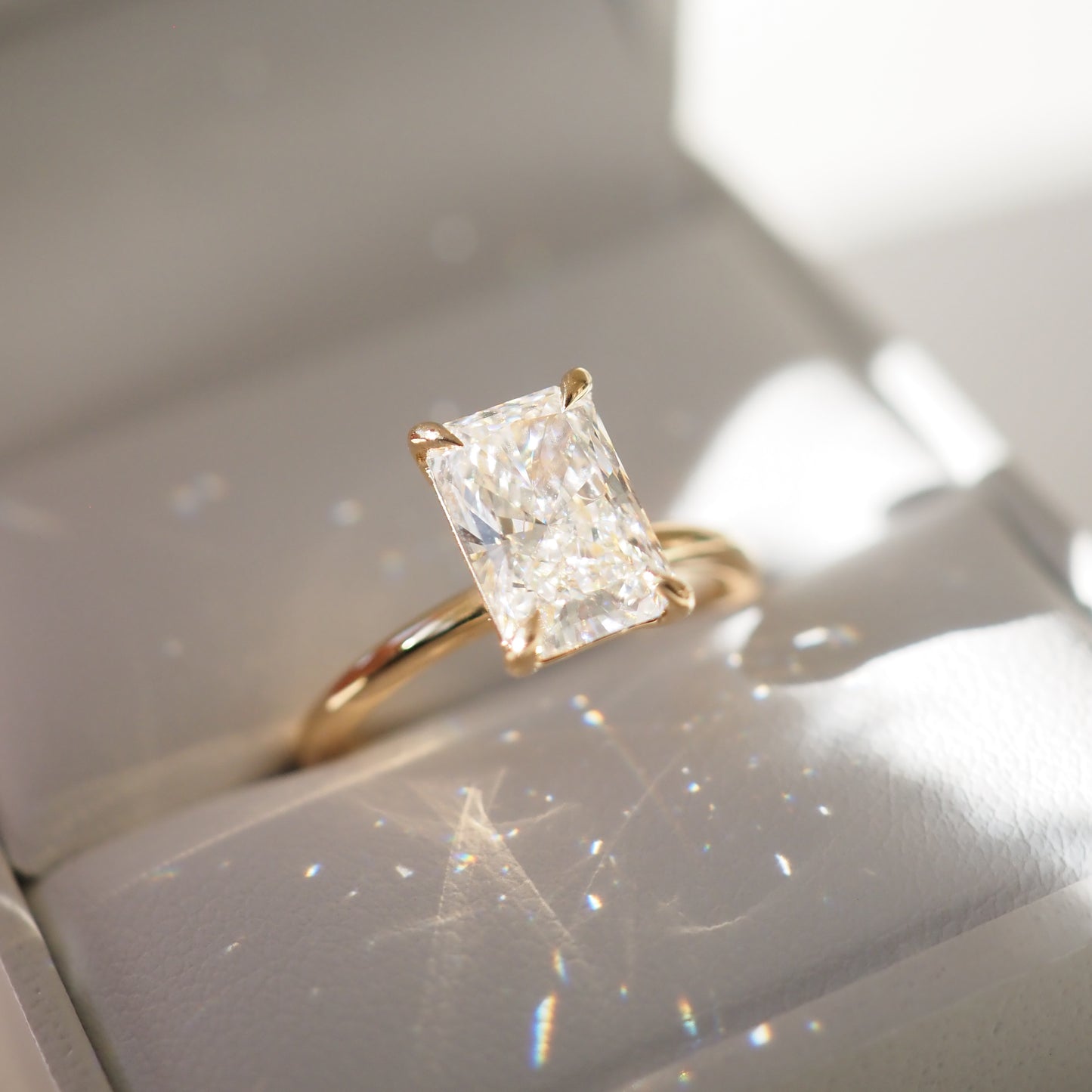 Gold ring with a large diamond on a white box background