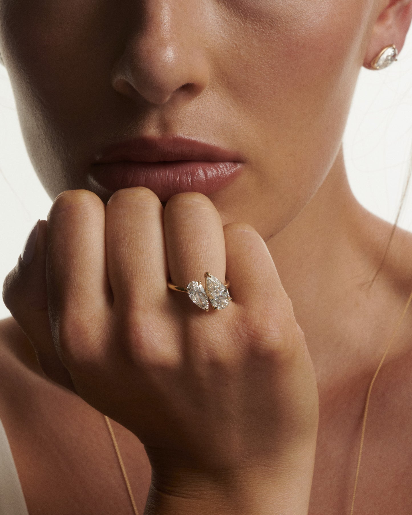 Close-up of a woman's hand wearing a diamond ring with a blurred background