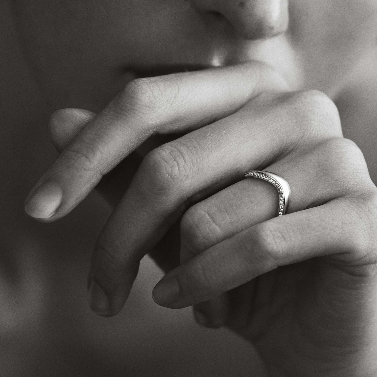 Close-up of a hand with a ring on a blurred background