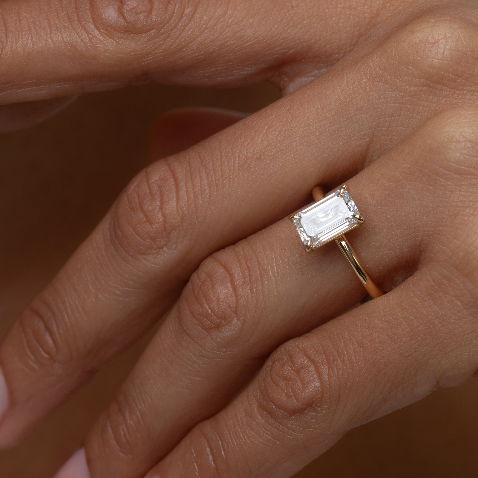 Gold ring with a diamond on a person's finger