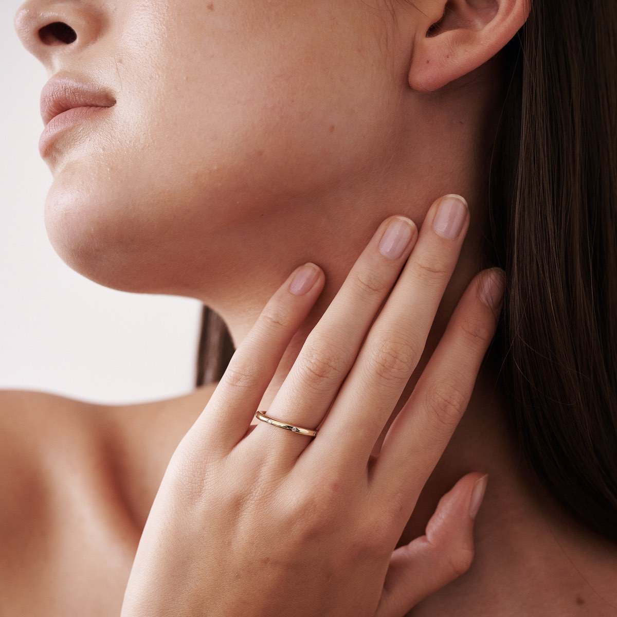 A solid gold round profile band for the modern minimalist — set with eight ornately set lab-grown diamonds spaced along the top or side edge.