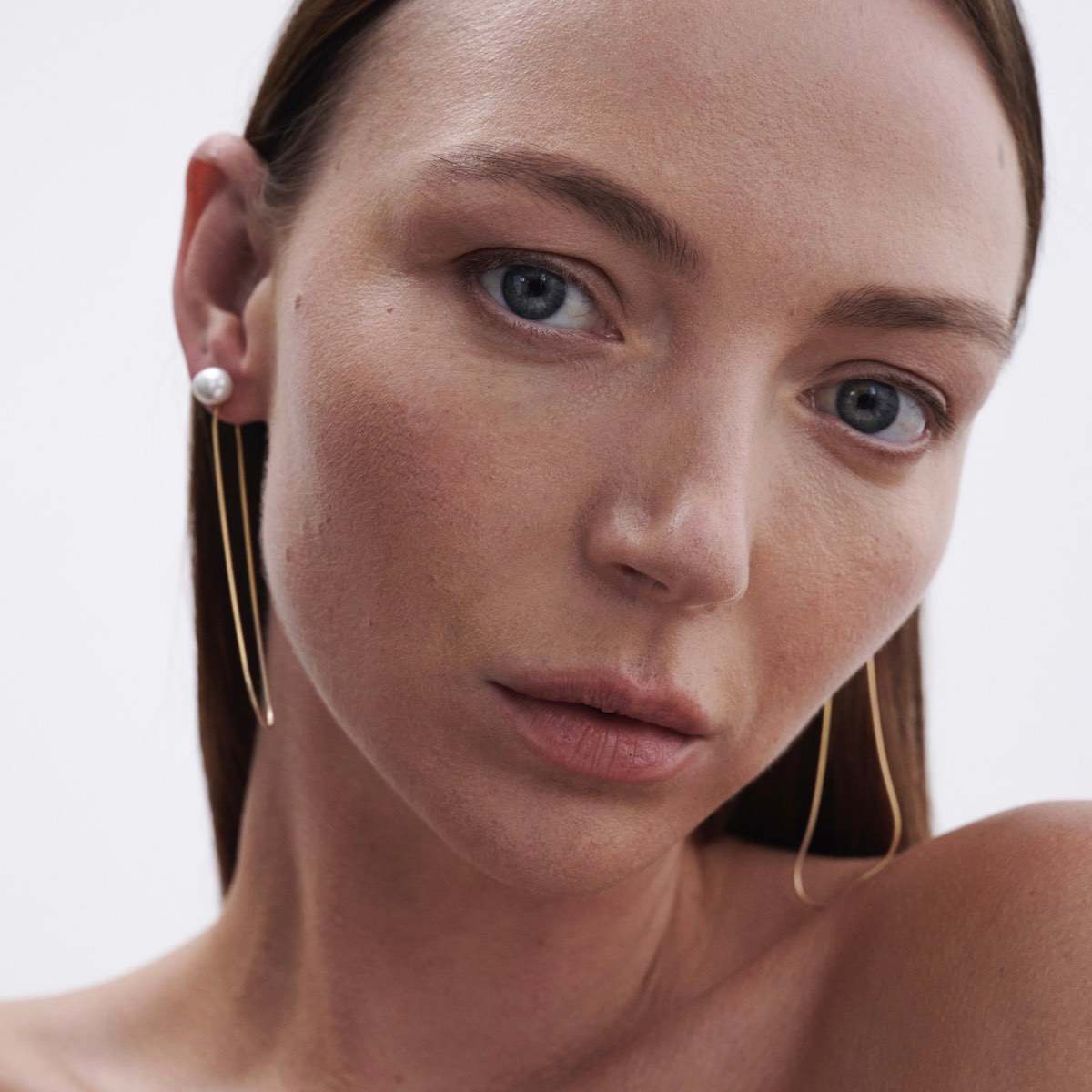 Model wears Natural Baroque Pearl Studs with Solid 9ct Yellow Gold Drops
[text overlay: Snake Chain Drops styled with our Pearl Studs]
