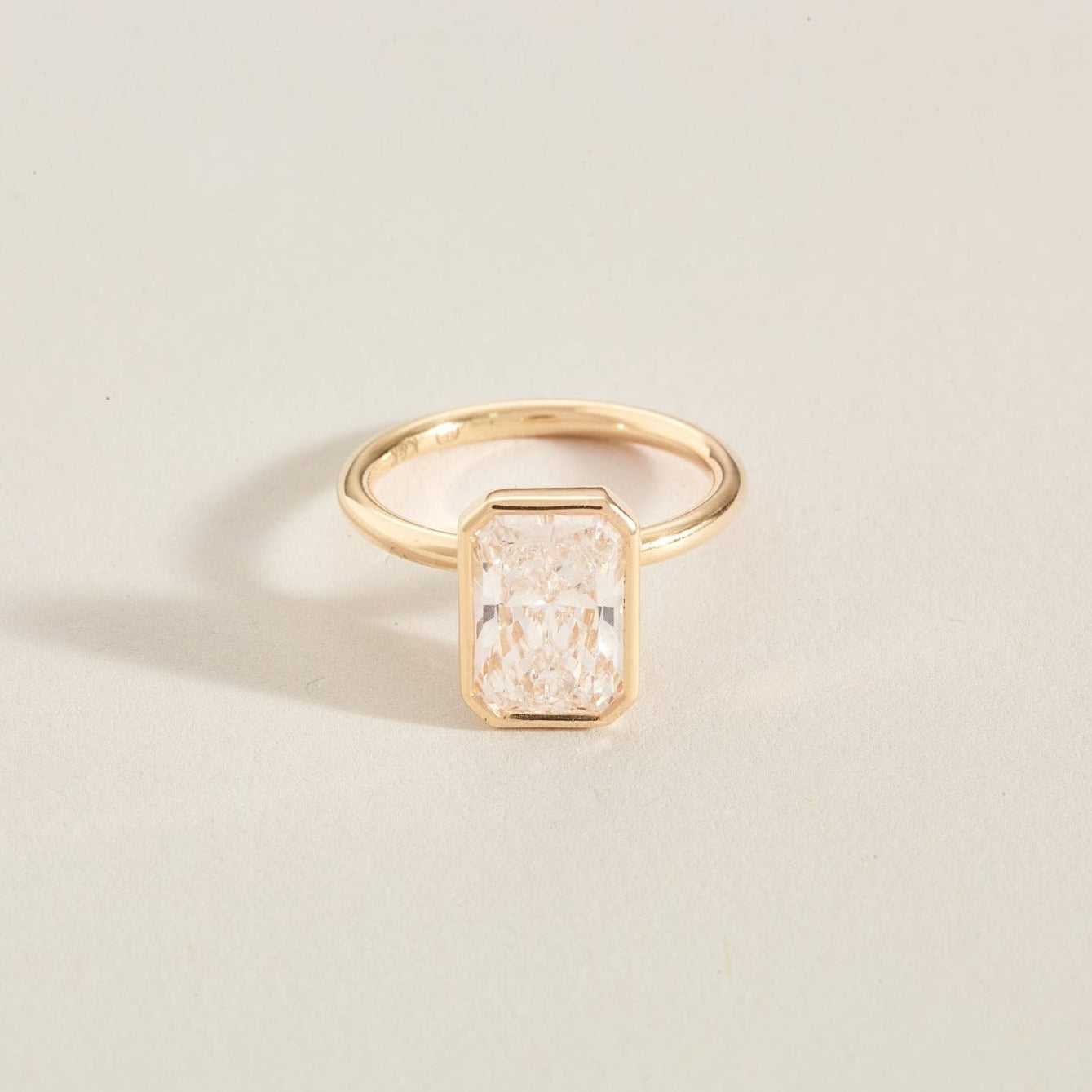 Gold diamond ring ona light beige background