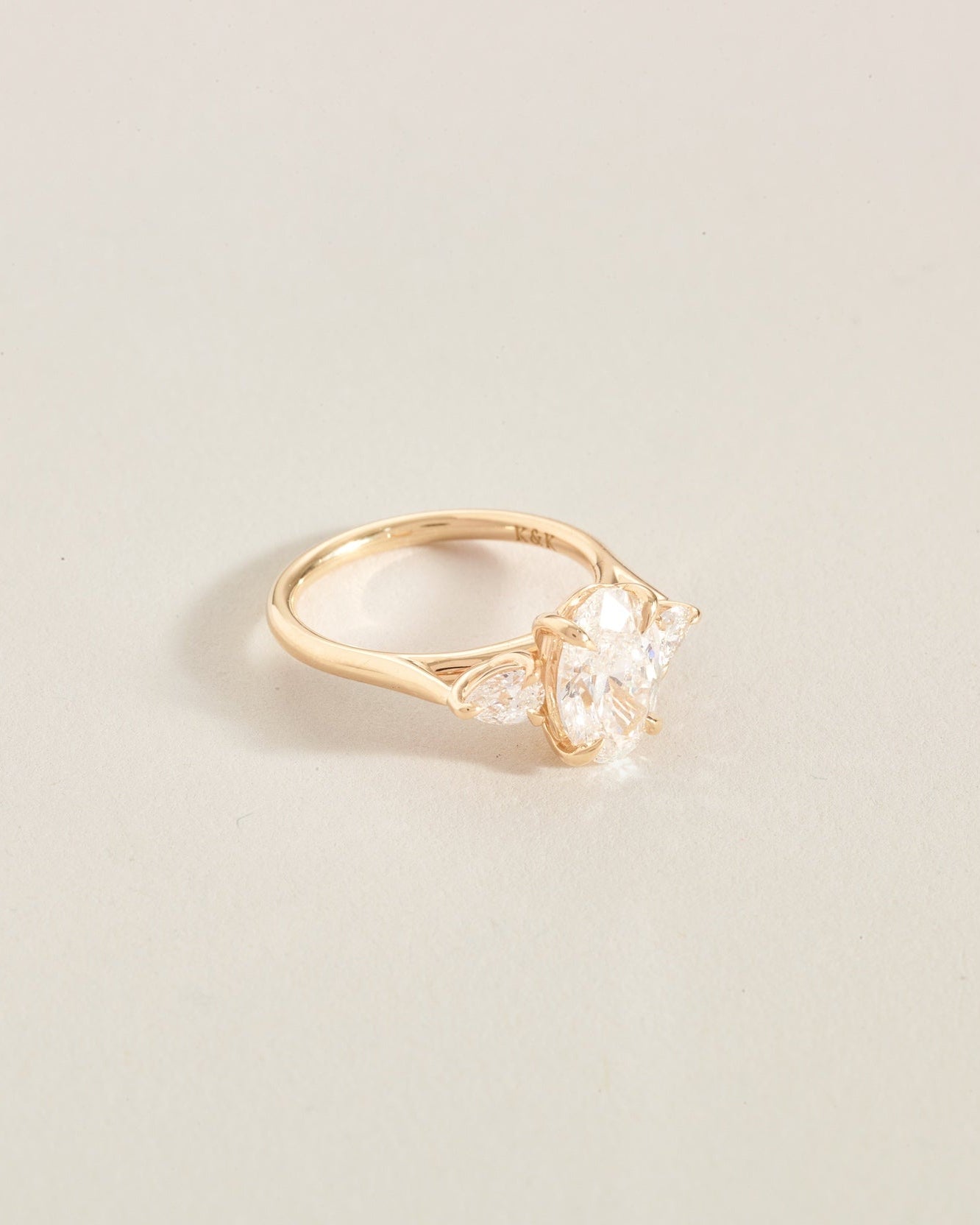 Gold ring with a 3 diamonds on a light beige background