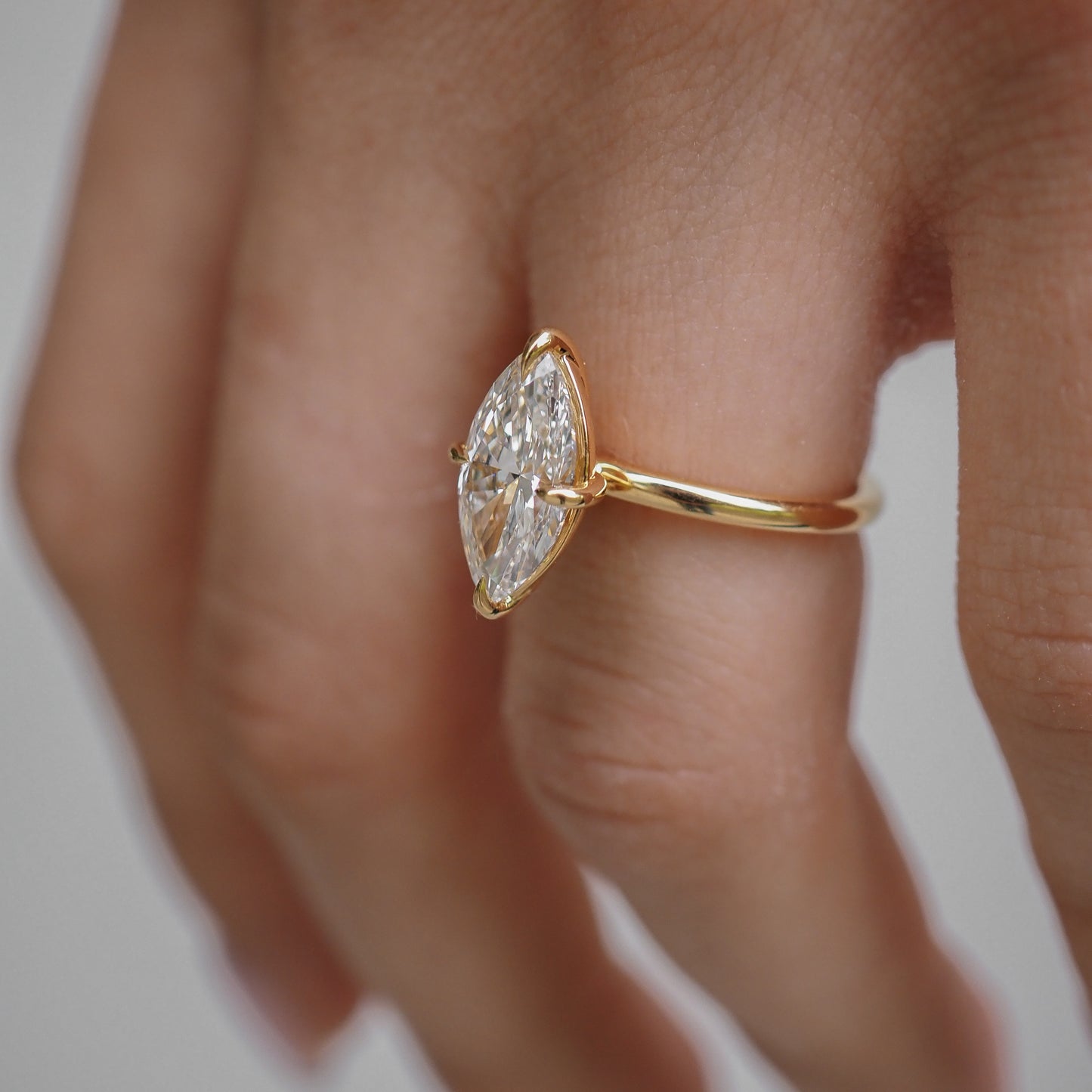 Marquise-cut diamond ring set in gold on a hand, showcasing luxury and elegance in jewellery design.