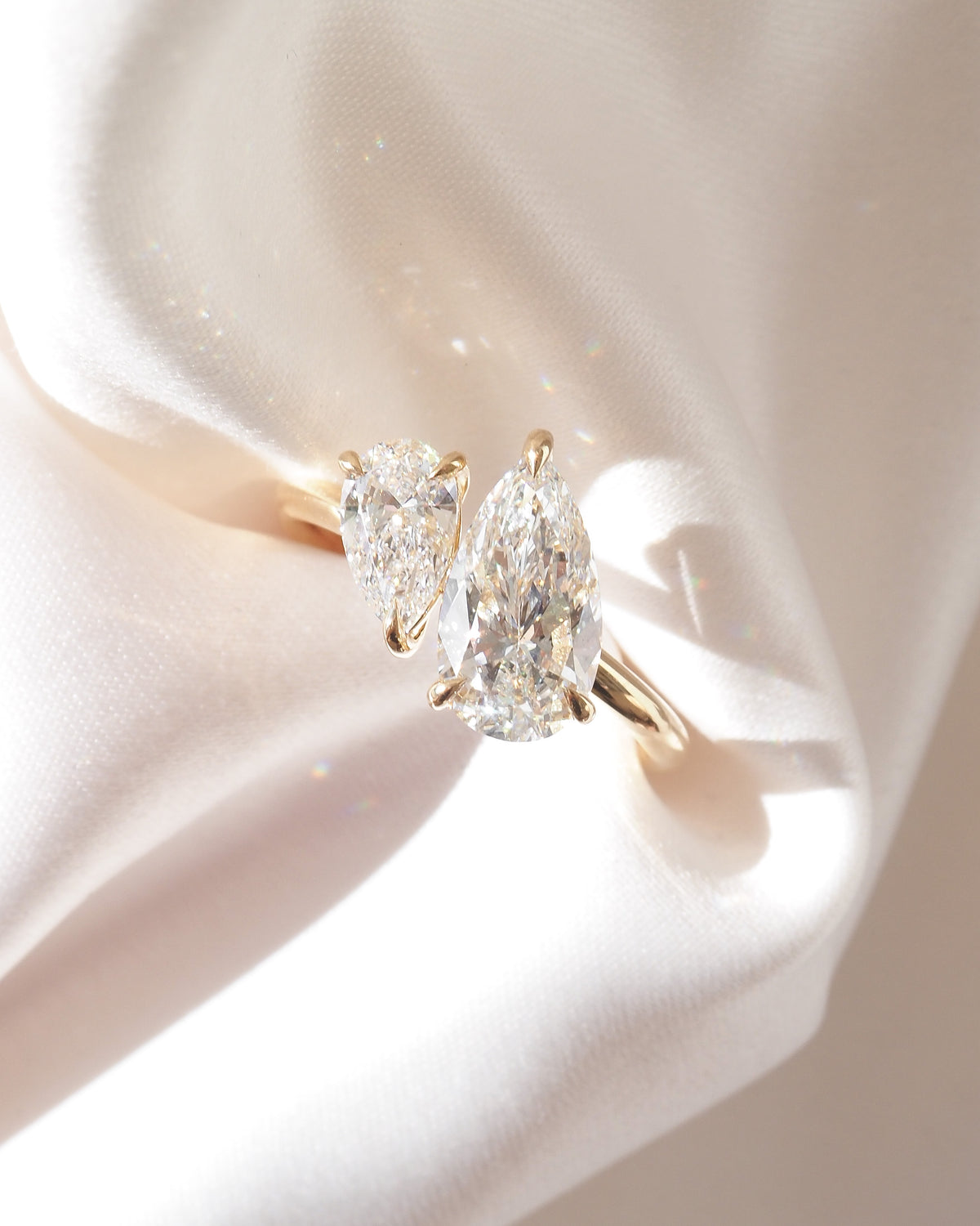 Gold engagement ring with two marquise lab-grown diamond stones, close-up