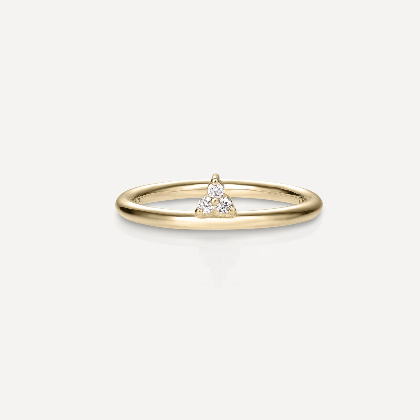 Delicate gold ring with a small triangular cluster of diamonds on a simple band, emphasising luxury simplicity. Perfect for minimalist jewellery lovers.