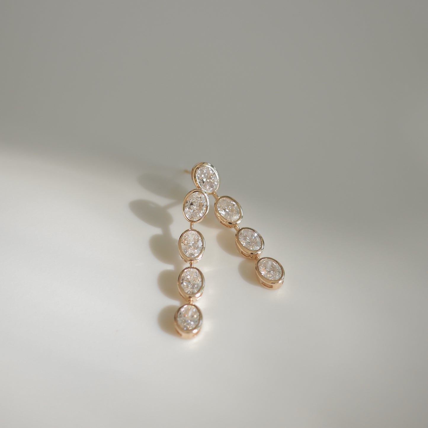 Elegant gold earrings adorned with oval diamonds, showcasing luxury jewellery design. Perfect for high-end fashion or special occasions.