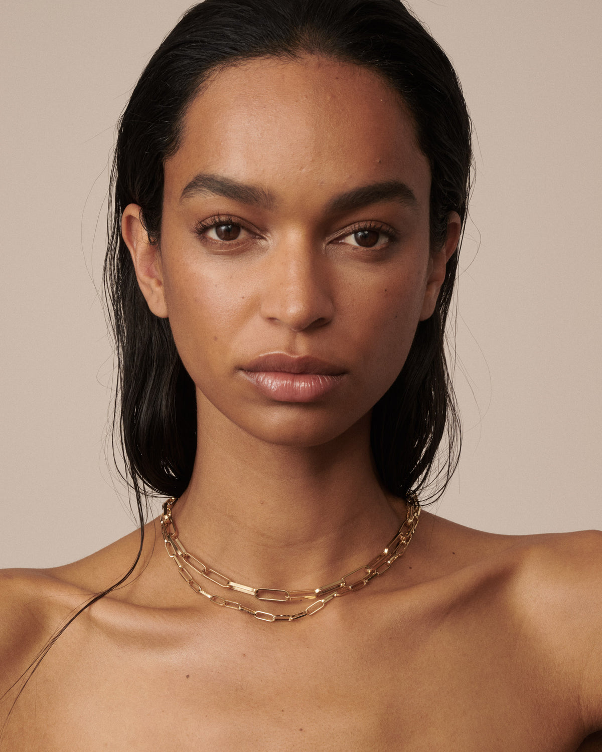 Model wears 2 widths of our gold paperlink necklaces, a fine version and a bold version. [text overlay: Francielle wears our Medium and Bold Paper Links]