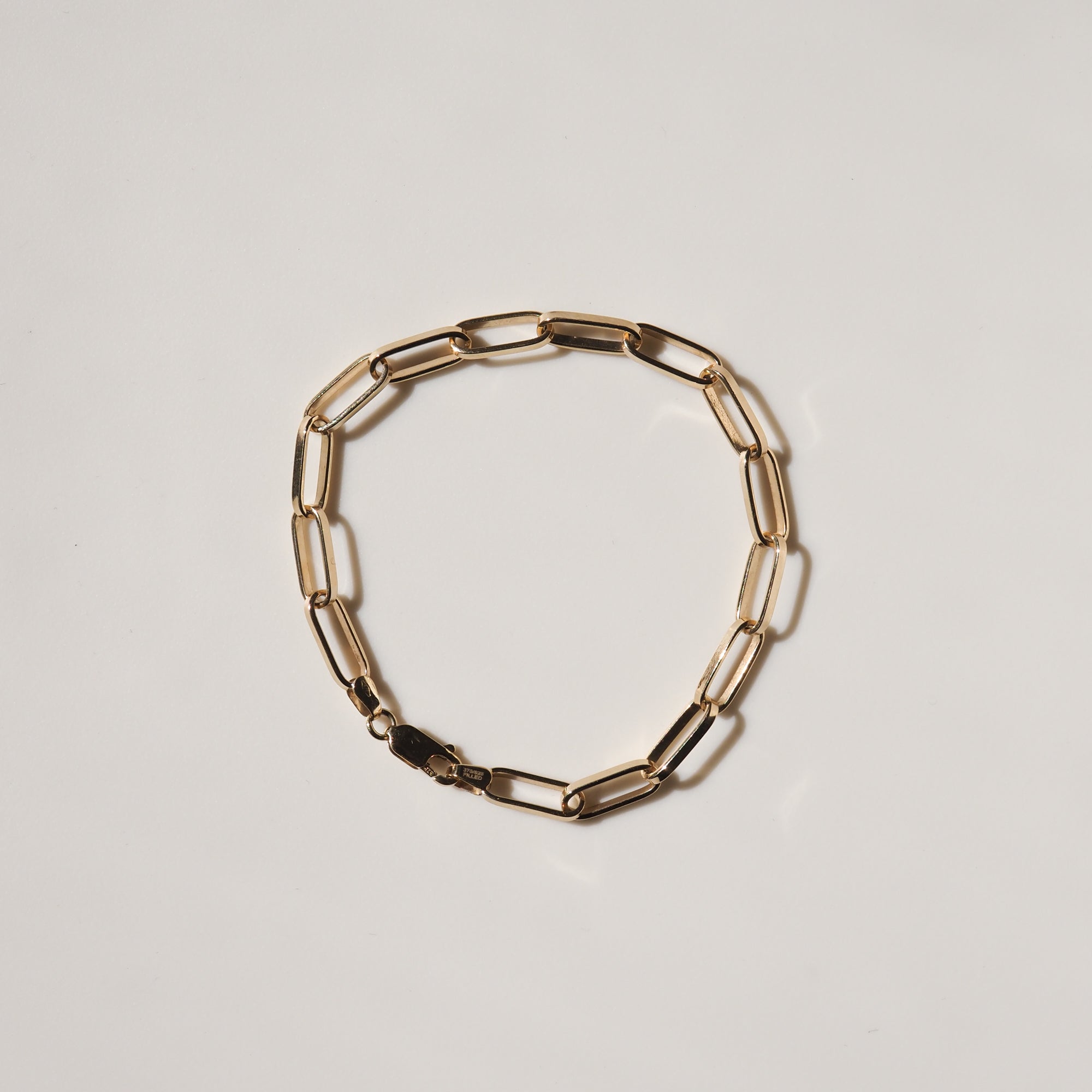 9ct gold paperclip link bracelet on a light background