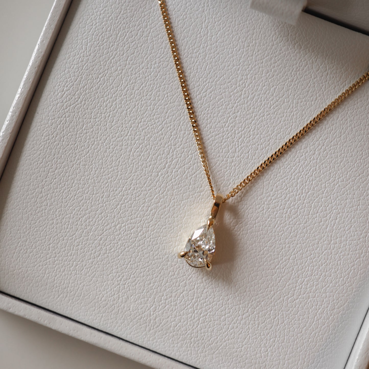 Gold necklace with pear-shaped diamond pendant in a white jewellery box. Perfect for luxury Australian jewellery lovers.