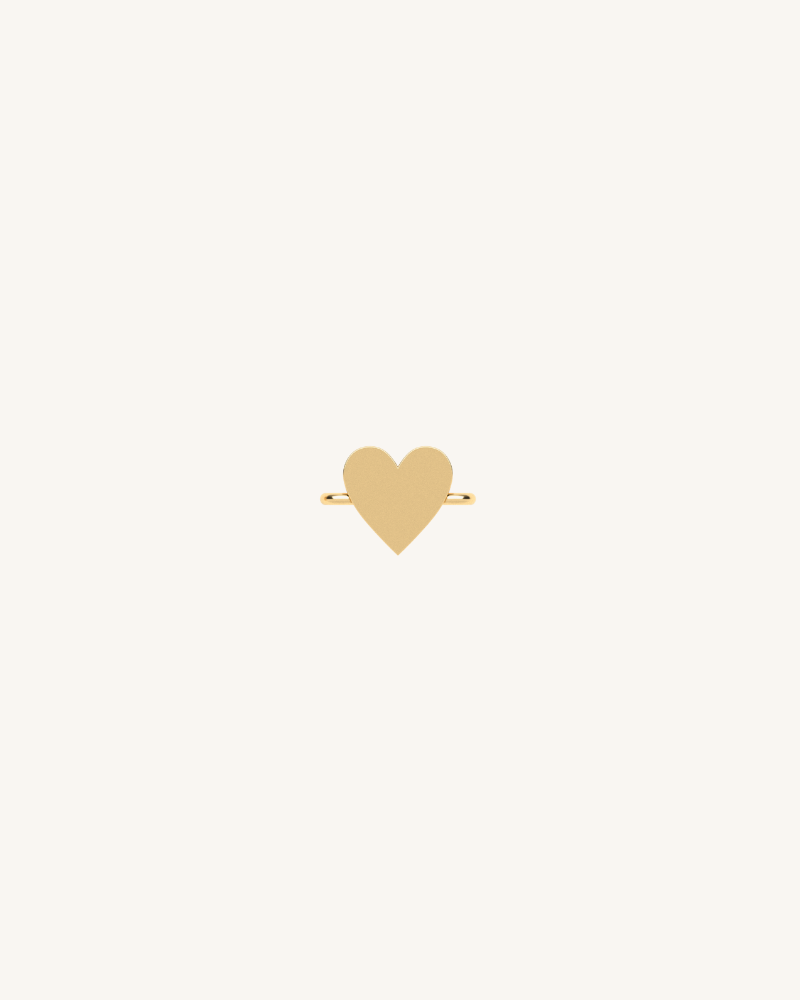 Gold heart charm on a beige background
