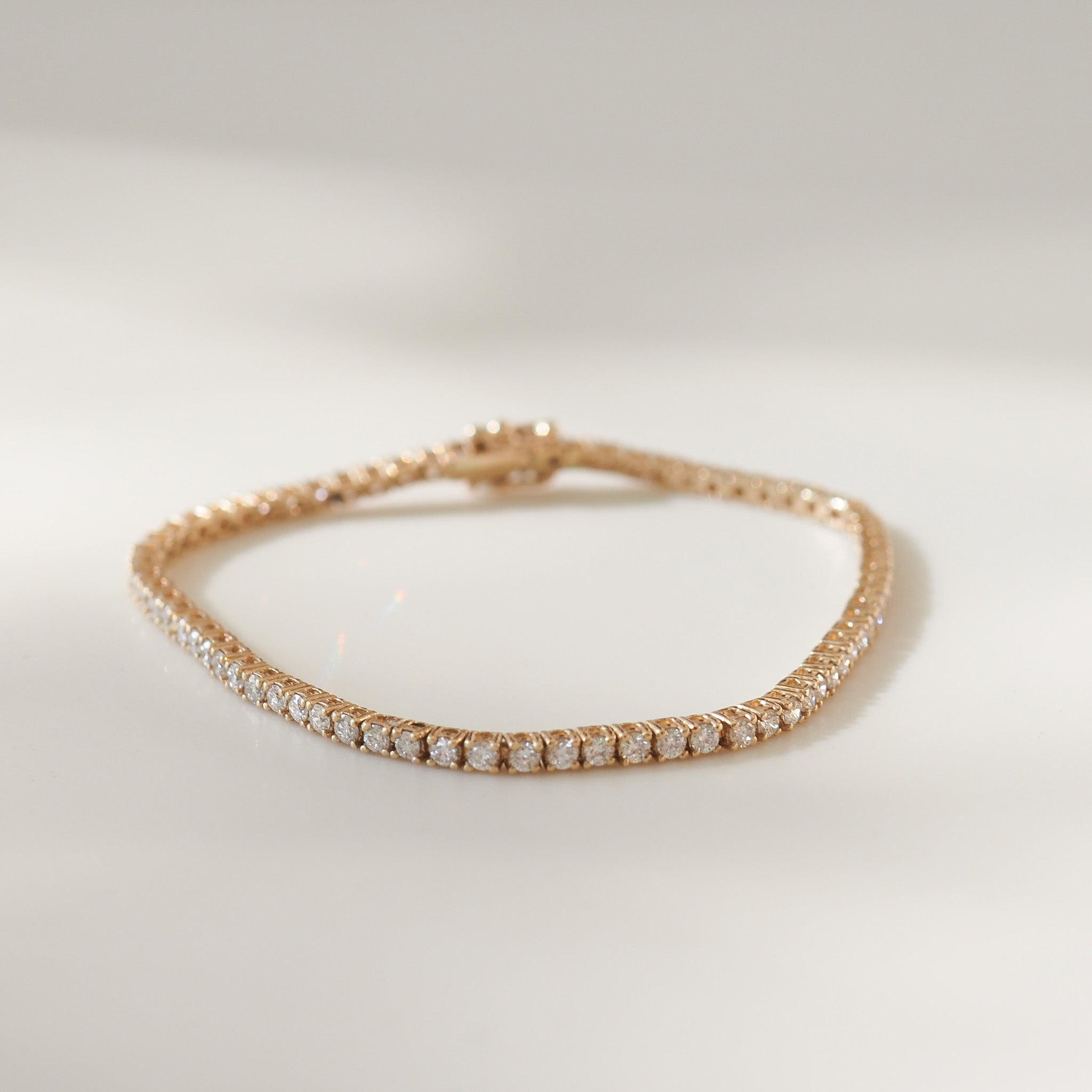 Yellow gold bracelet with diamonds on a light background