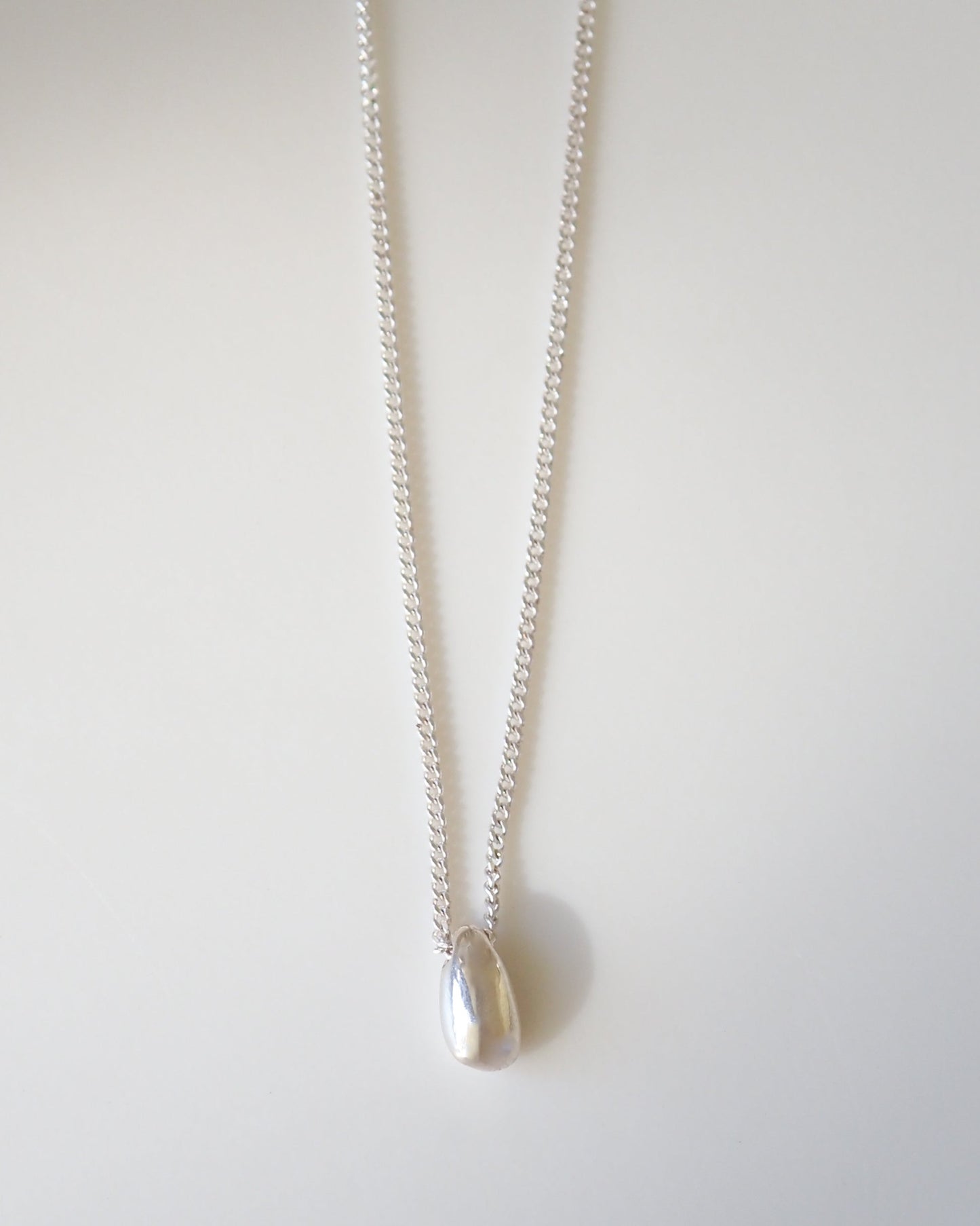 Silver necklace with a pendant on a white background