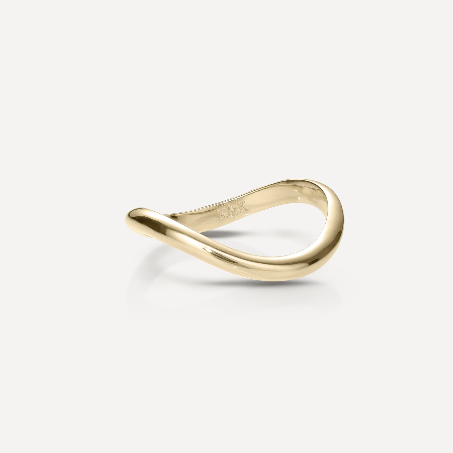 Elegant gold wave ring on a light background, featuring a modern, twisted design. Perfect for luxury jewellery enthusiasts.