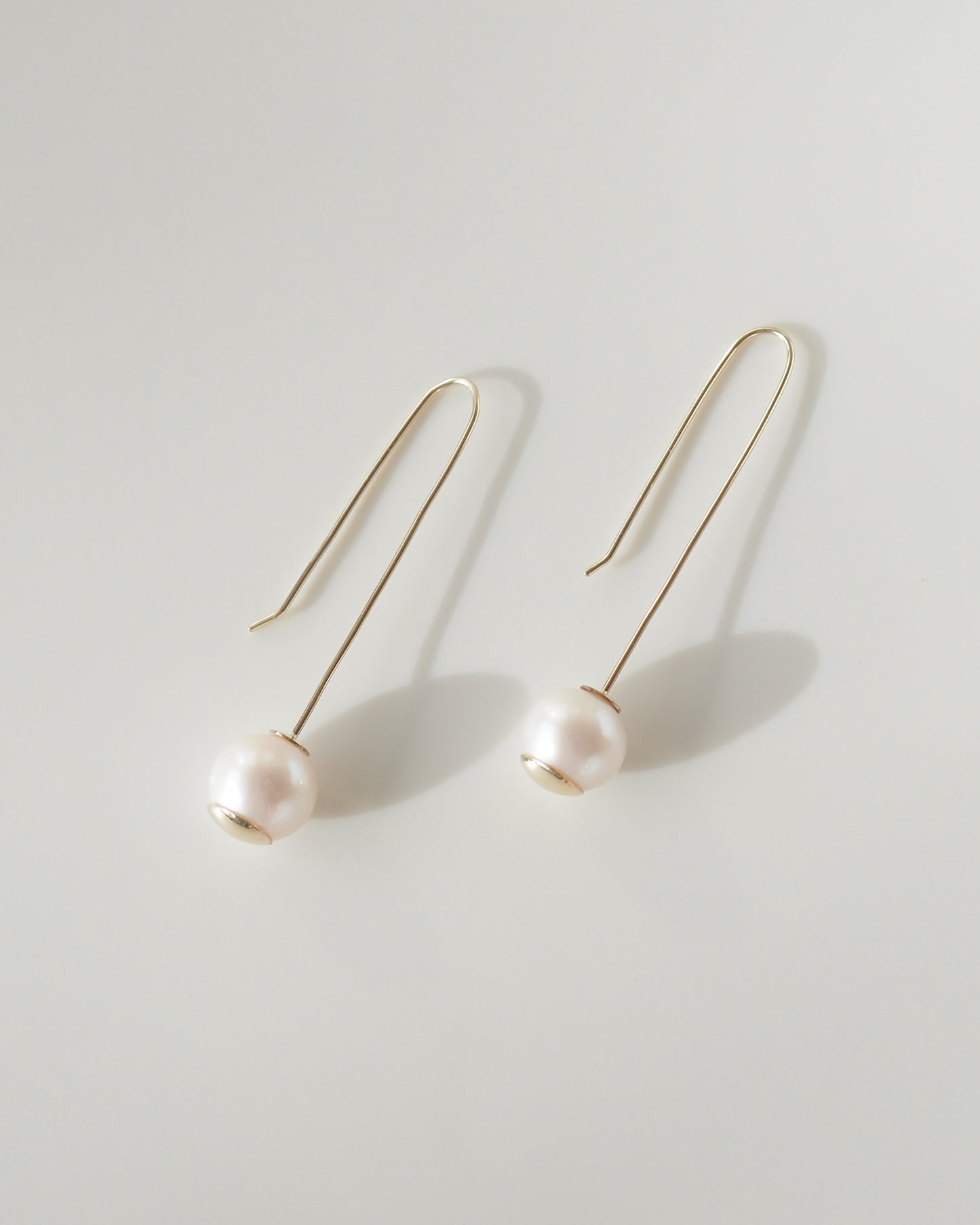 Pearl earrings on a light gray background