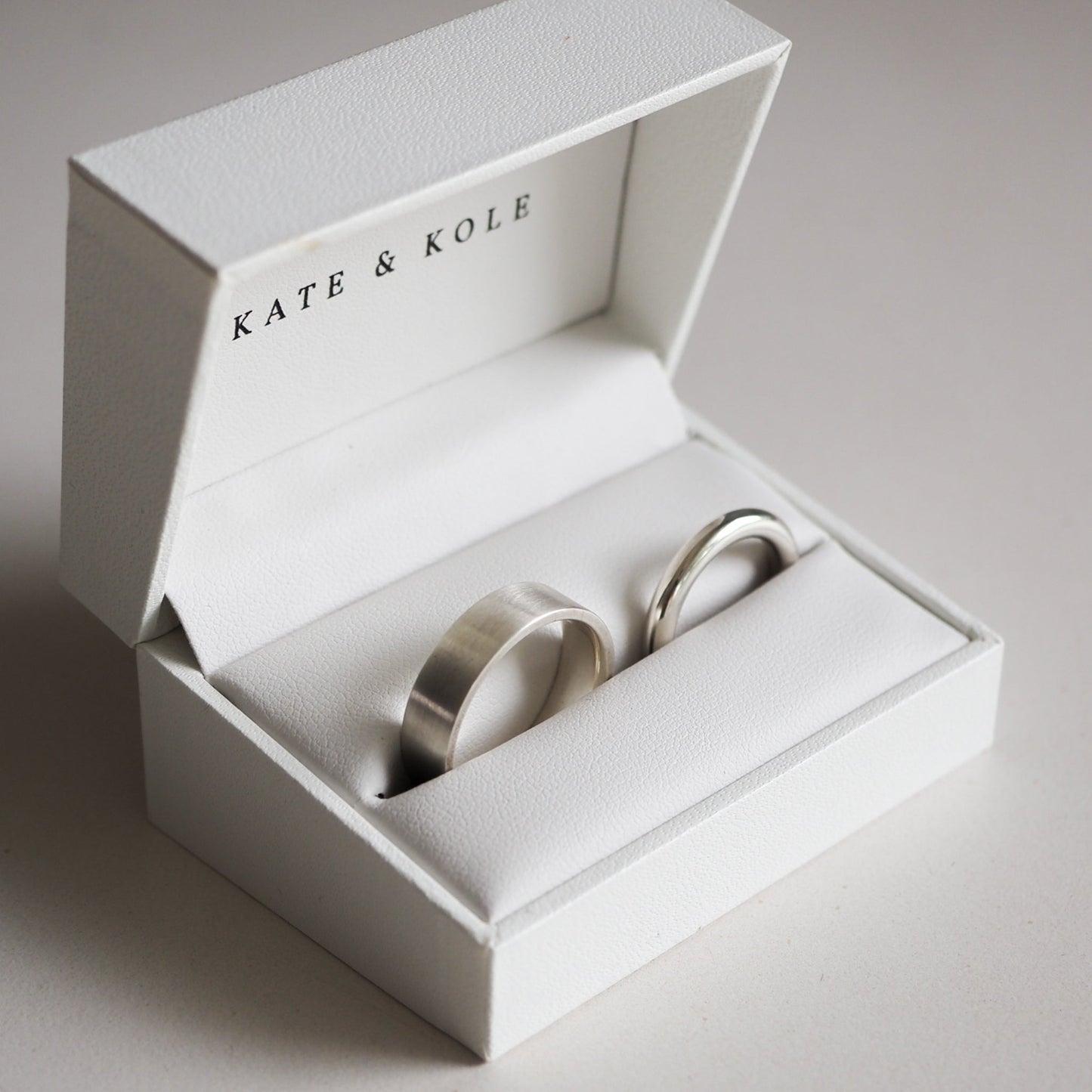 Elegant silver rings displayed in a luxurious white "KATE & KOLE" jewellery box, perfect for weddings or special occasions.